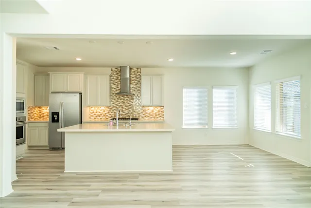 a kitchen with stainless steel appliances kitchen island granite countertop a stove and a sink