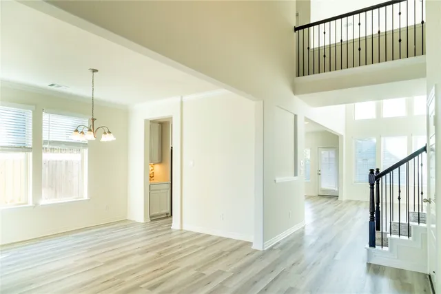 a view of a hallway with wooden floor and staircase