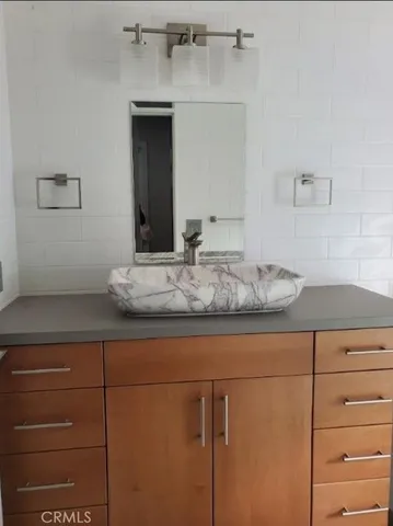 a bathroom with a granite countertop sink and a mirror
