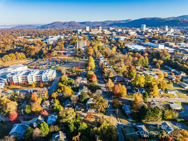 an aerial view of mountain with residential buildings and mountain view in back