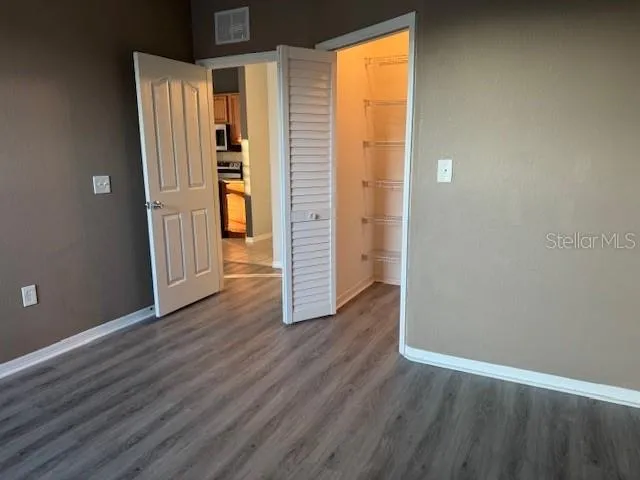 an empty room with wooden floor and closet