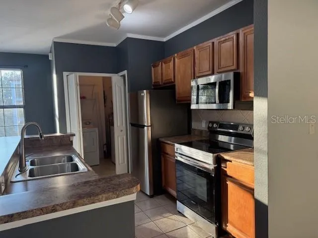 a kitchen with stainless steel appliances granite countertop a refrigerator a stove and a sink with wooden floor