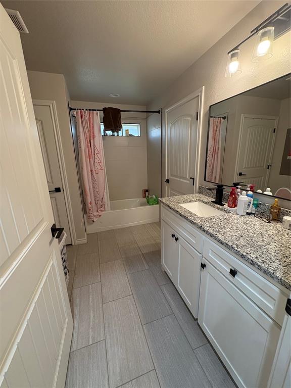 1610 Ridgeview Circle Granbury, TX 76048 - Photo 10 of 13 a bathroom with a granite countertop sink a mirror and a shower