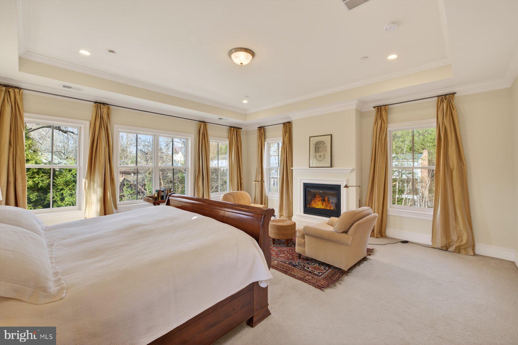 6115 Madawaska Road Bethesda, MD 20816 - Photo 32 of 78 a spacious bedroom with a large bed and a fireplace