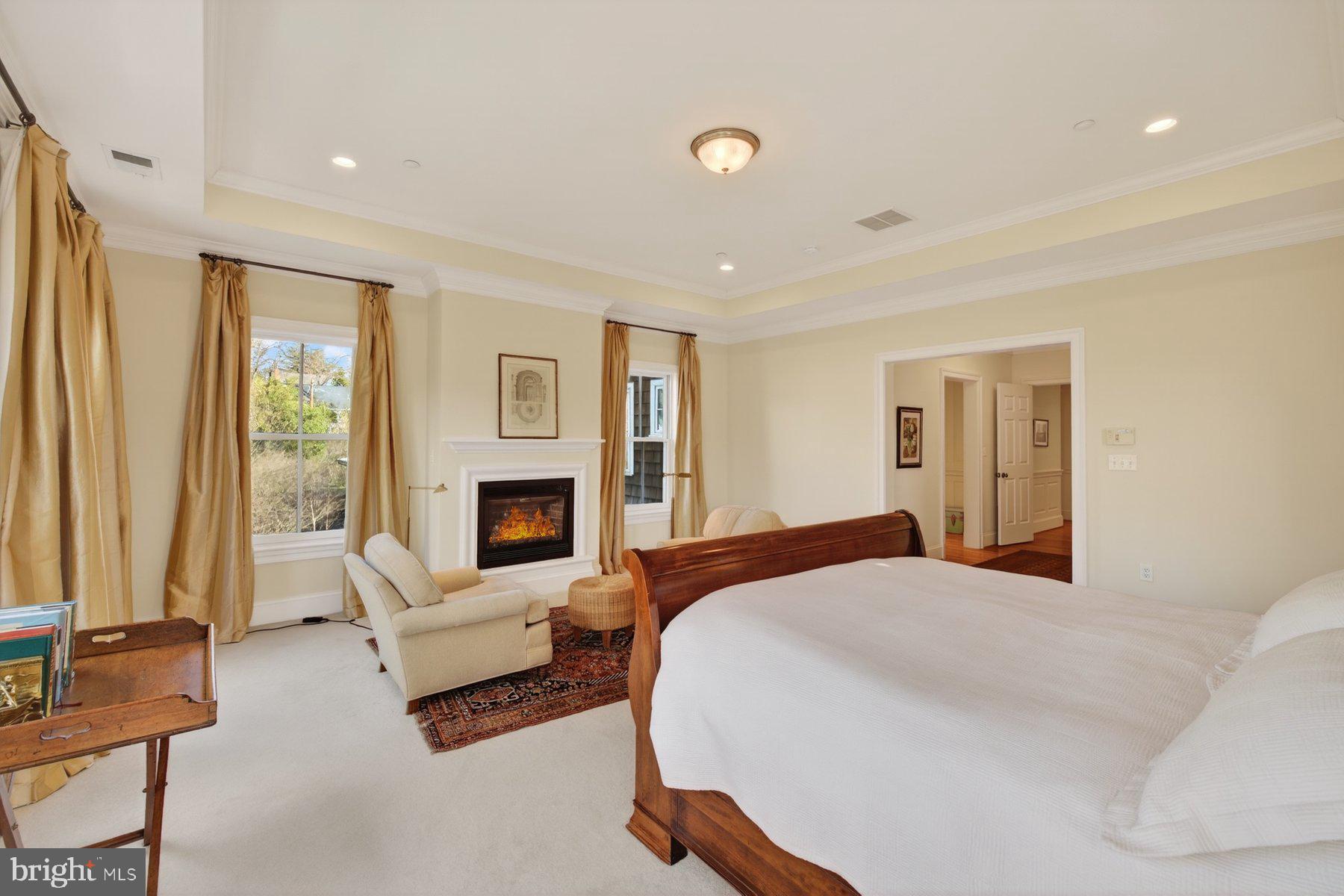 6115 Madawaska Road Bethesda, MD 20816 - Photo 33 of 78 a spacious bedroom with a large bed and a fireplace