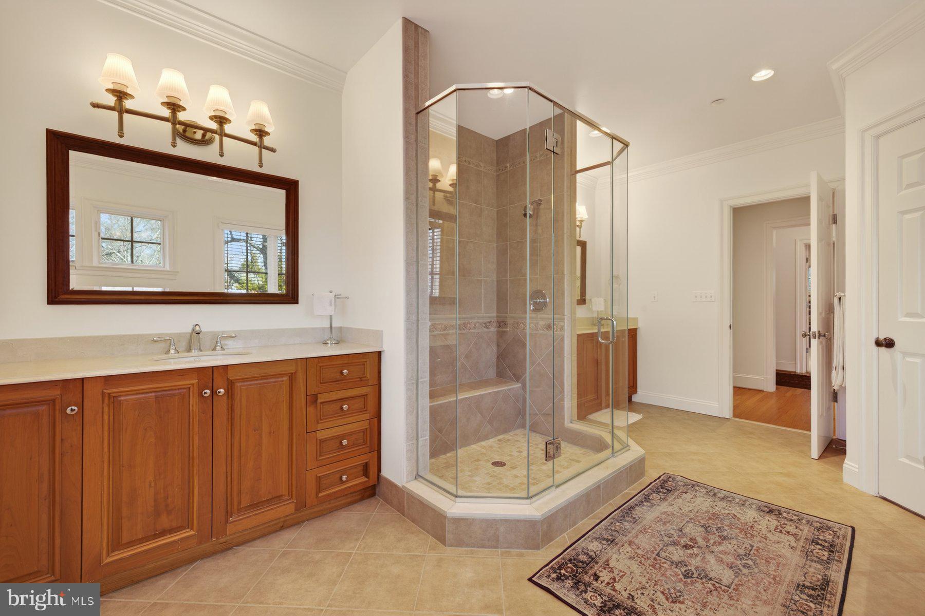 6115 Madawaska Road Bethesda, MD 20816 - Photo 38 of 78 a bathroom with a tub a double vanity sink and a mirror