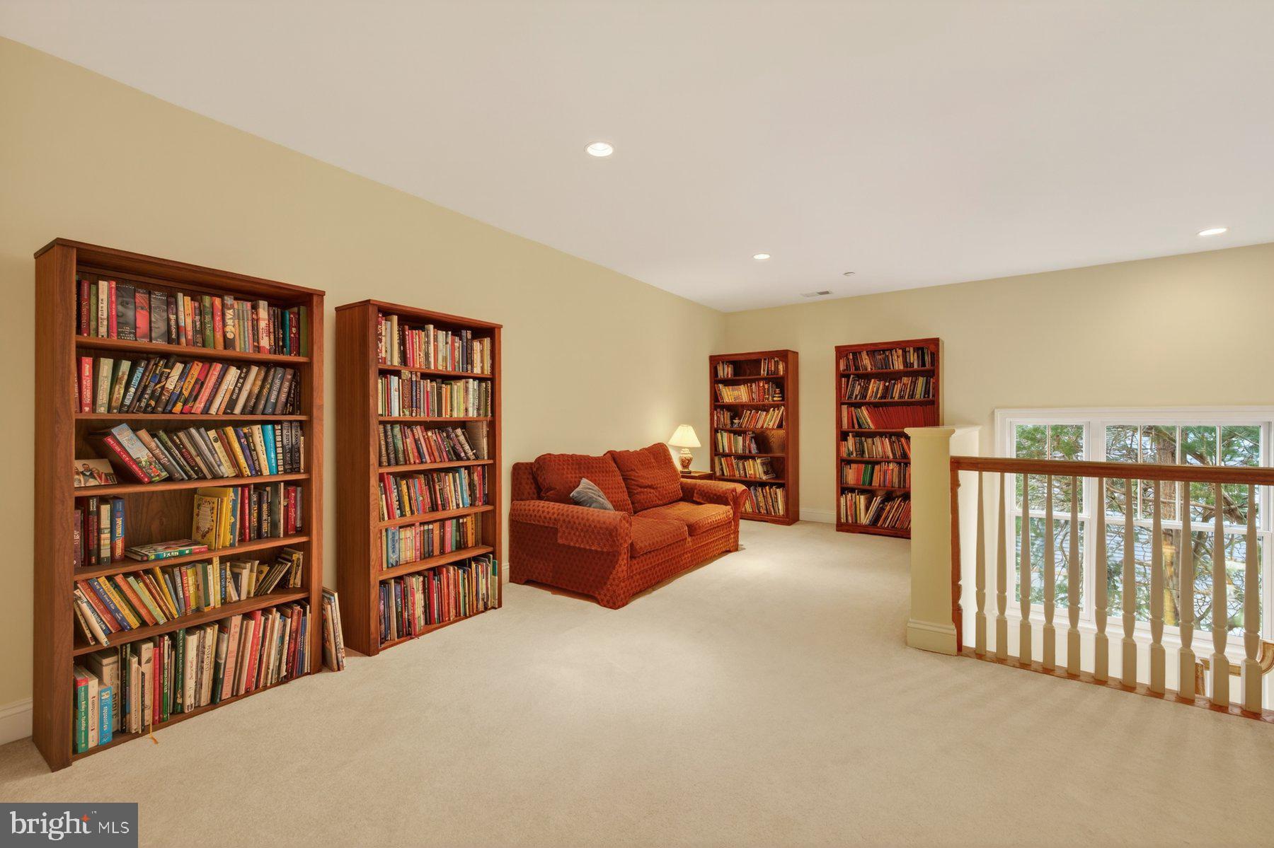 6115 Madawaska Road Bethesda, MD 20816 - Photo 52 of 78 a living room with furniture a bookshelf and a book shelf
