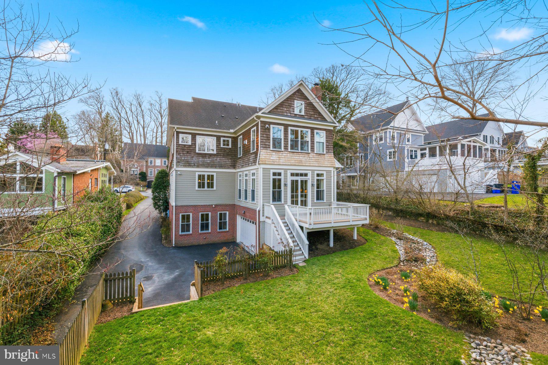6115 Madawaska Road Bethesda, MD 20816 - Photo 70 of 78 a front view of a house with a garden and lake view