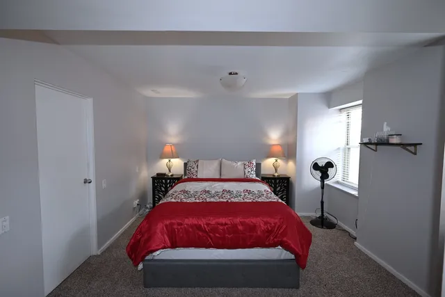 a bed sitting in a bedroom next to a lamp