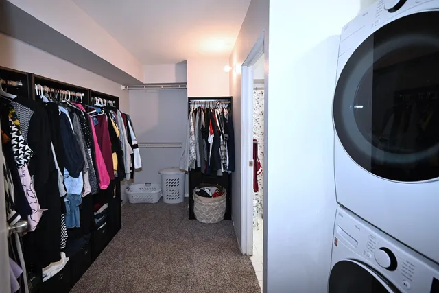 a view of walk in closet with clothes and shoes