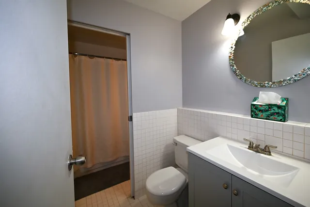 a bathroom with a granite countertop sink toilet and mirror