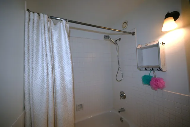 a bathroom with a shower curtain and a shower