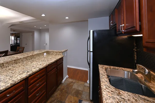 a kitchen with granite countertop a refrigerator and a sink