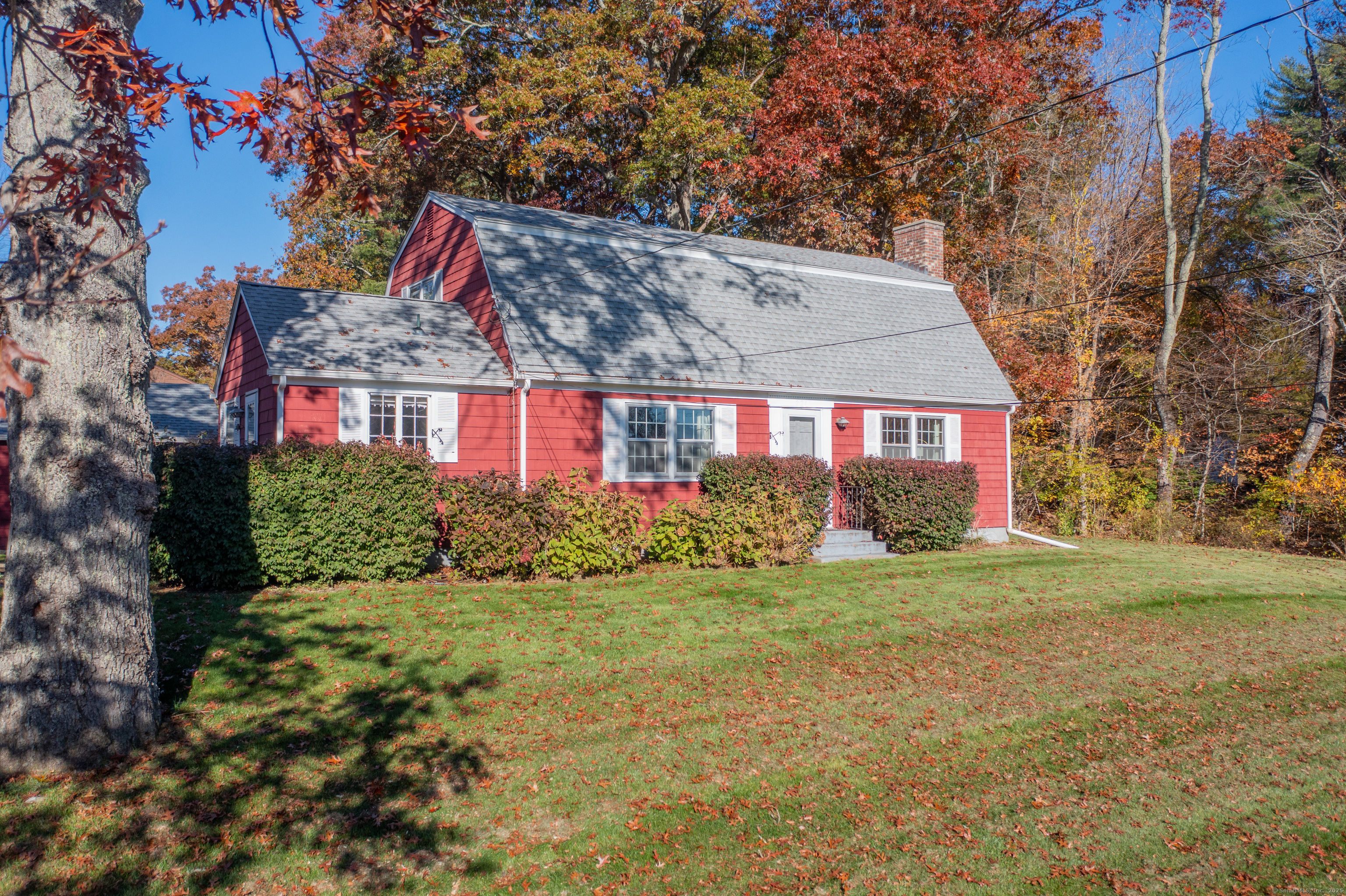 a view of a house next to a big yard and large trees