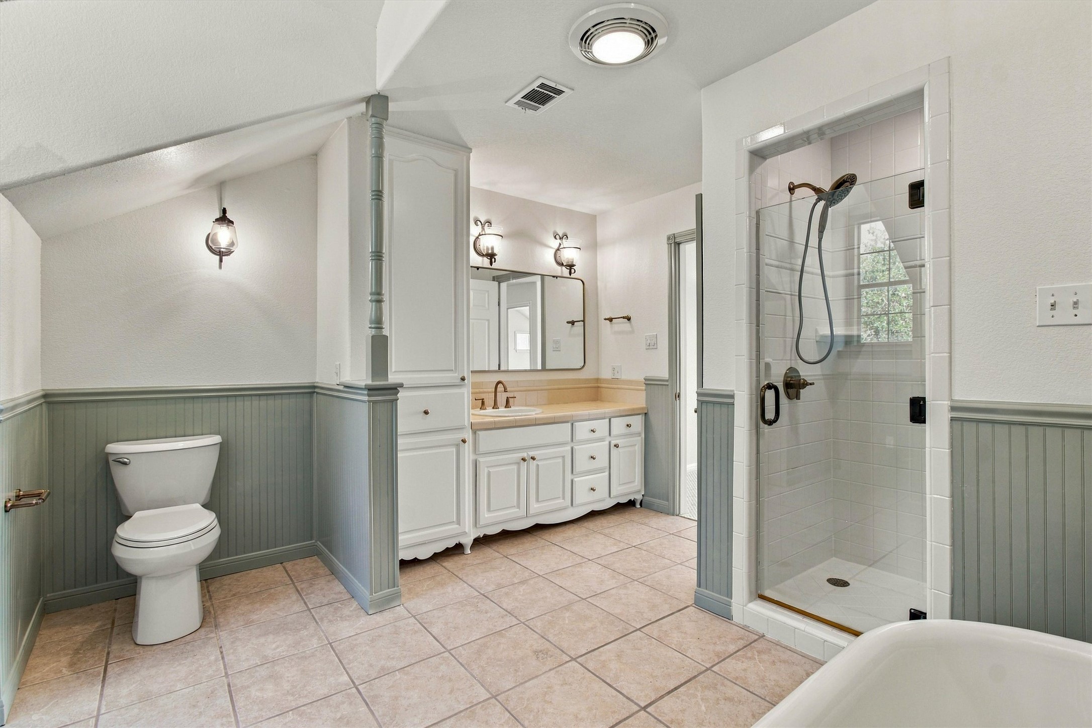 1651 Old Red Ranch Road Dripping Springs, TX 78620 - Photo 21 of 31 Tiled flooring, clean wainscoting, and a walk-in tiled shower define this functional bathroom layout.
