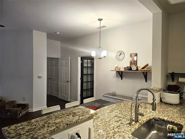 a kitchen with stainless steel appliances granite countertop a sink a stove and a wooden floors