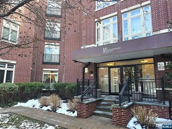 a view of a building with a large window and potted plants