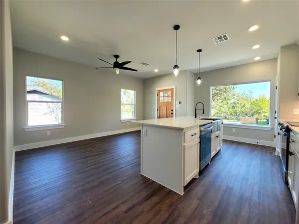 a kitchen with stainless steel appliances granite countertop wooden floors and white walls