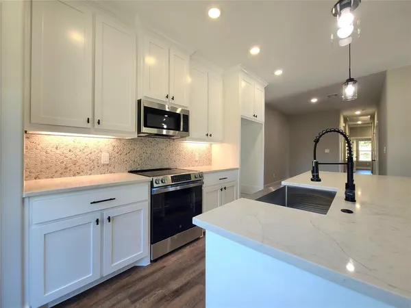 a kitchen with kitchen island a sink stainless steel appliances and cabinets