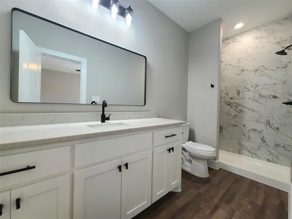 a bathroom with a sink a toilet and shower