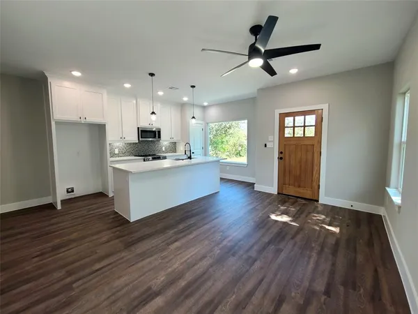 a view of kitchen with cabinets appliances wooden floor and window