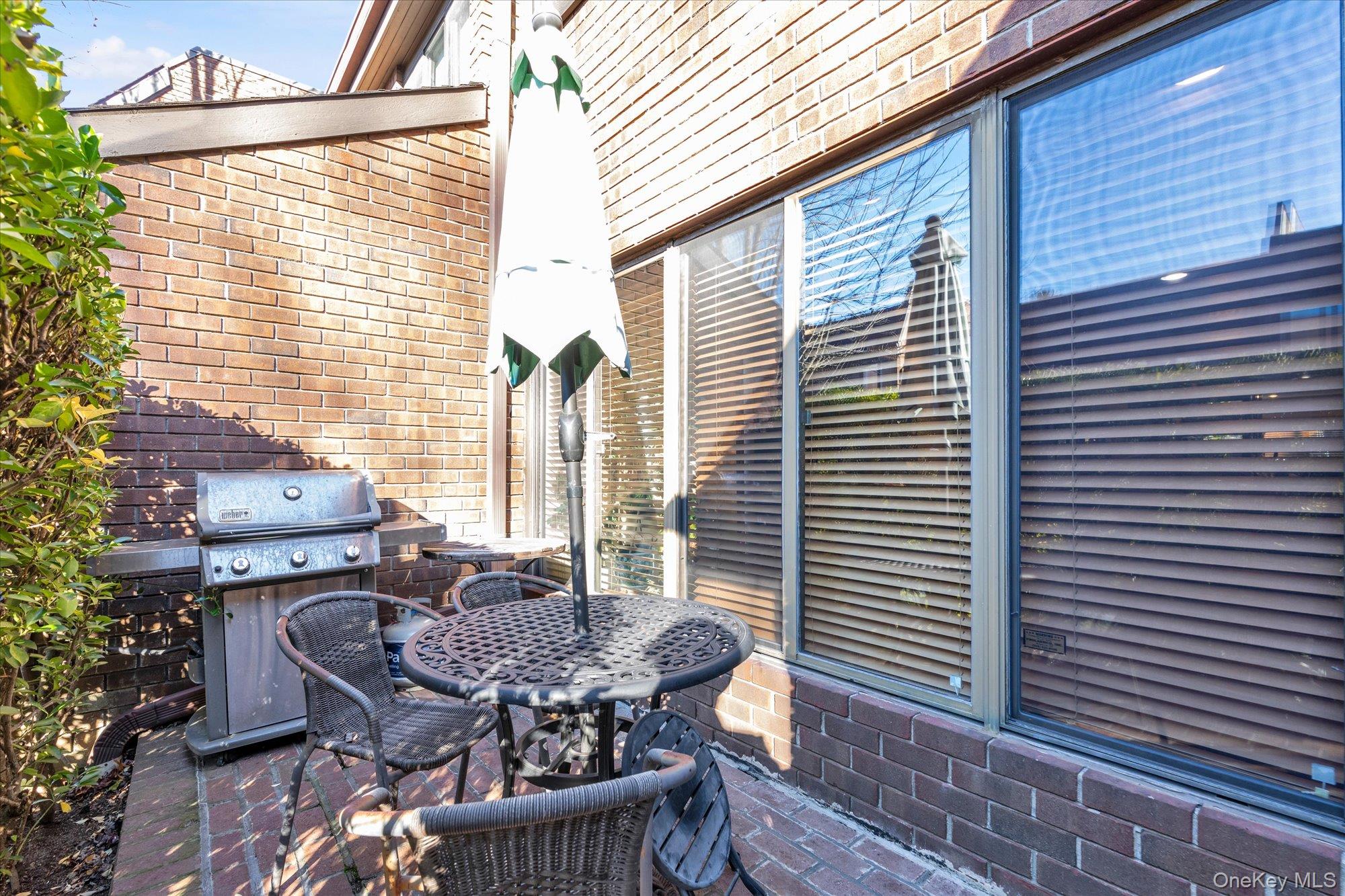 15 Spring Hollow Road Roslyn, NY 11576 - Photo 3 of 30 a view of a patio with table and chairs and potted plants