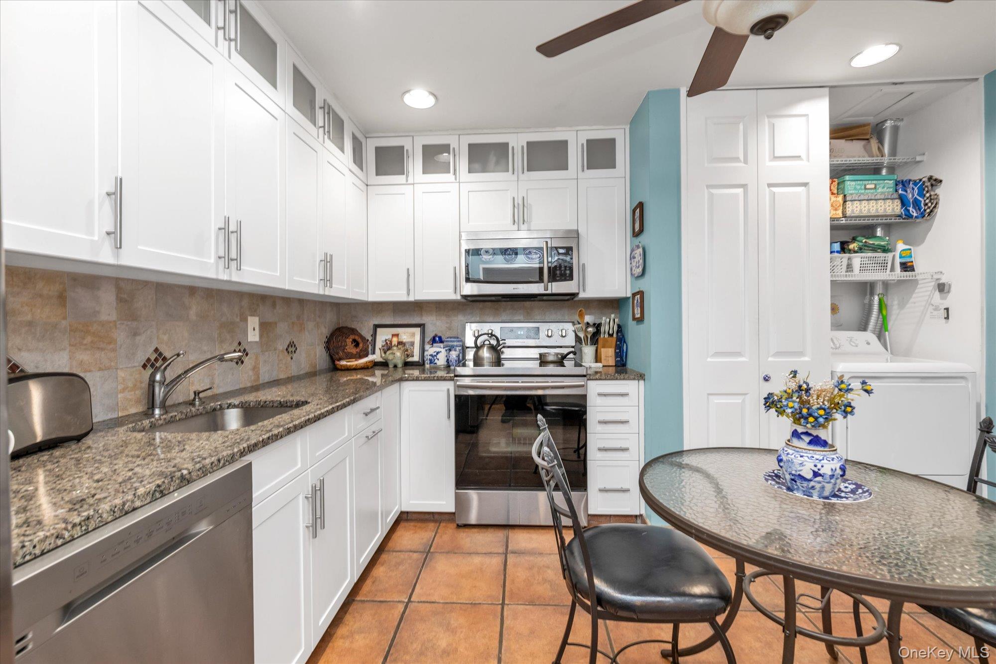 15 Spring Hollow Road Roslyn, NY 11576 - Photo 10 of 30 a kitchen with granite countertop stainless steel appliances a sink a stove a table and chairs
