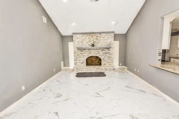 a view of empty room with fireplace and window