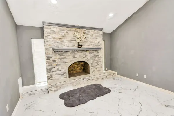 a view of a livingroom with a fireplace and a chandelier fan