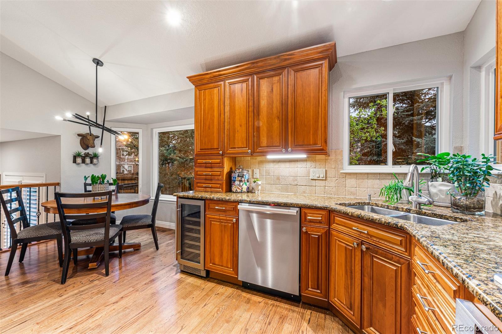 7340 Rattlesnake Drive Lone Tree, CO 80124 - Photo 11 of 33 a kitchen with stainless steel appliances granite countertop sink stove and wooden floor