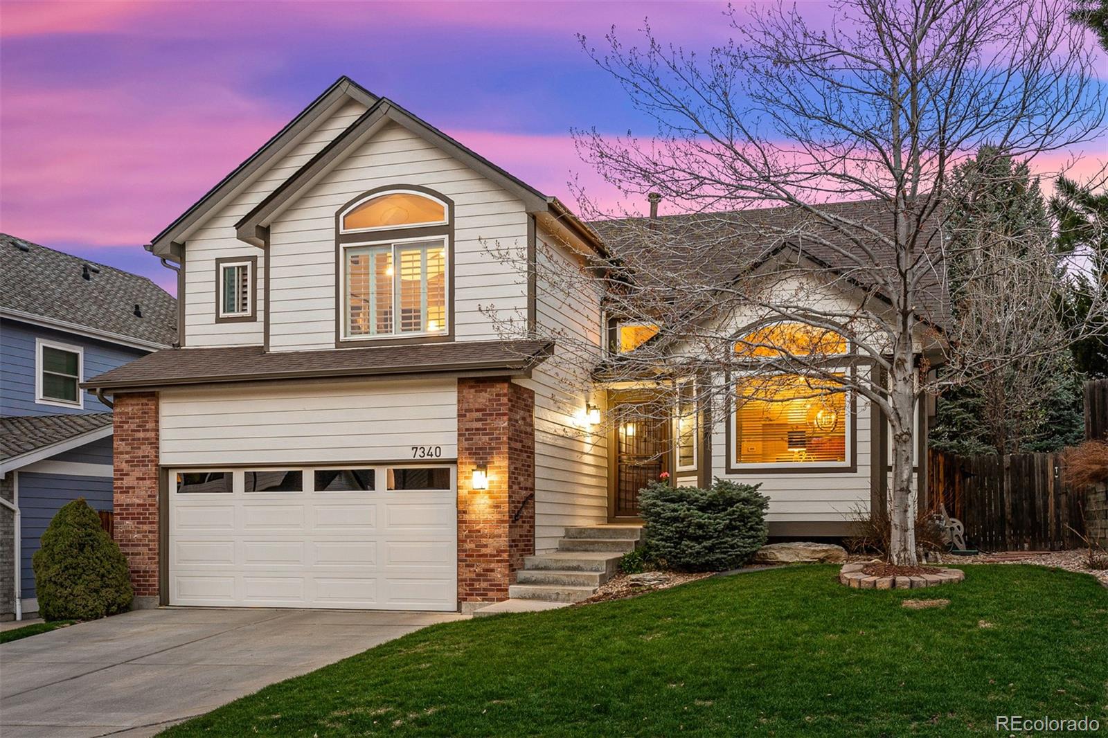 7340 Rattlesnake Drive Lone Tree, CO 80124 - Photo 2 of 33 a front view of a house with a garden and plants