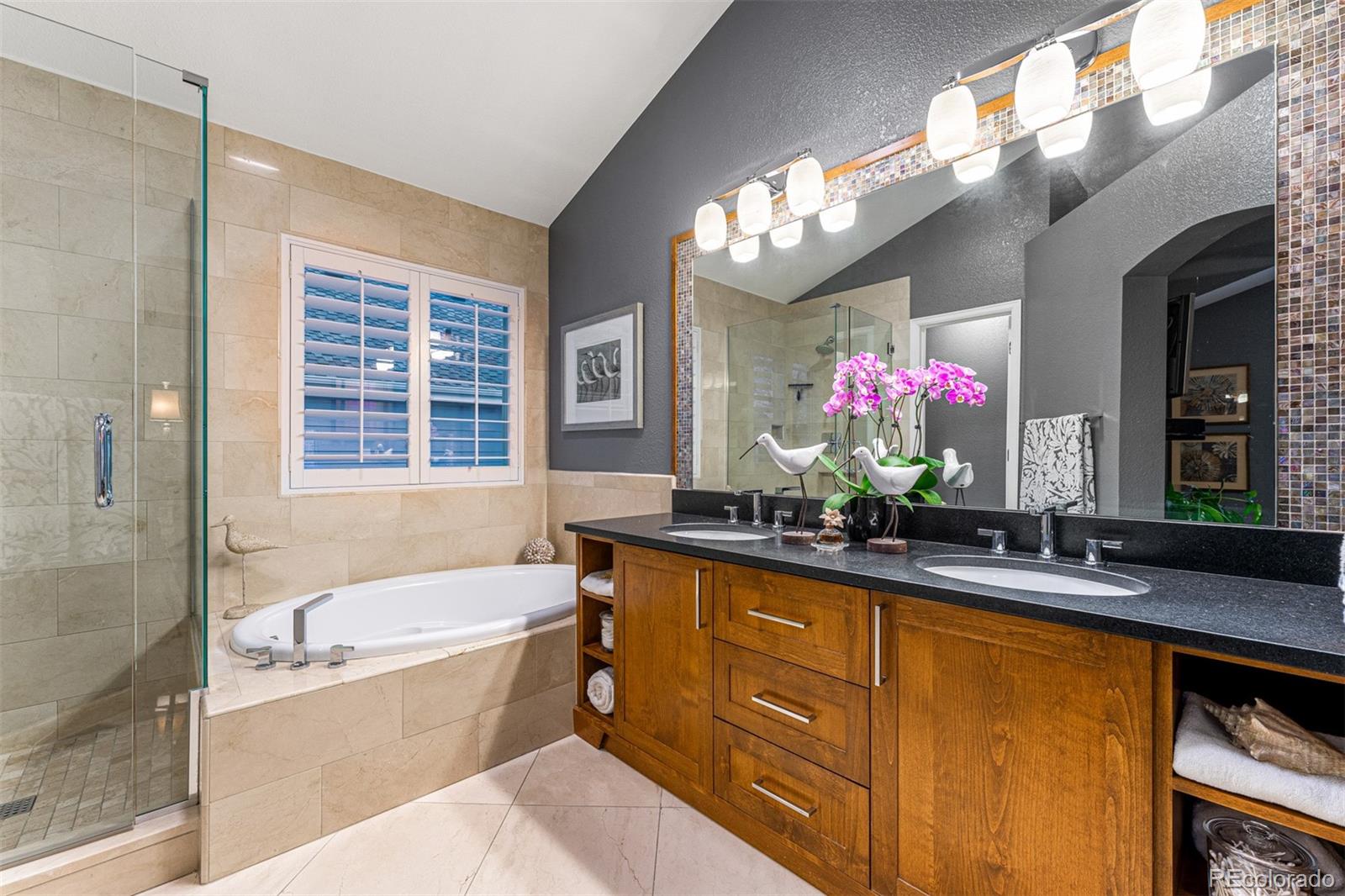 7340 Rattlesnake Drive Lone Tree, CO 80124 - Photo 21 of 33 a bathroom with a tub a sink double vanity granite and mirror