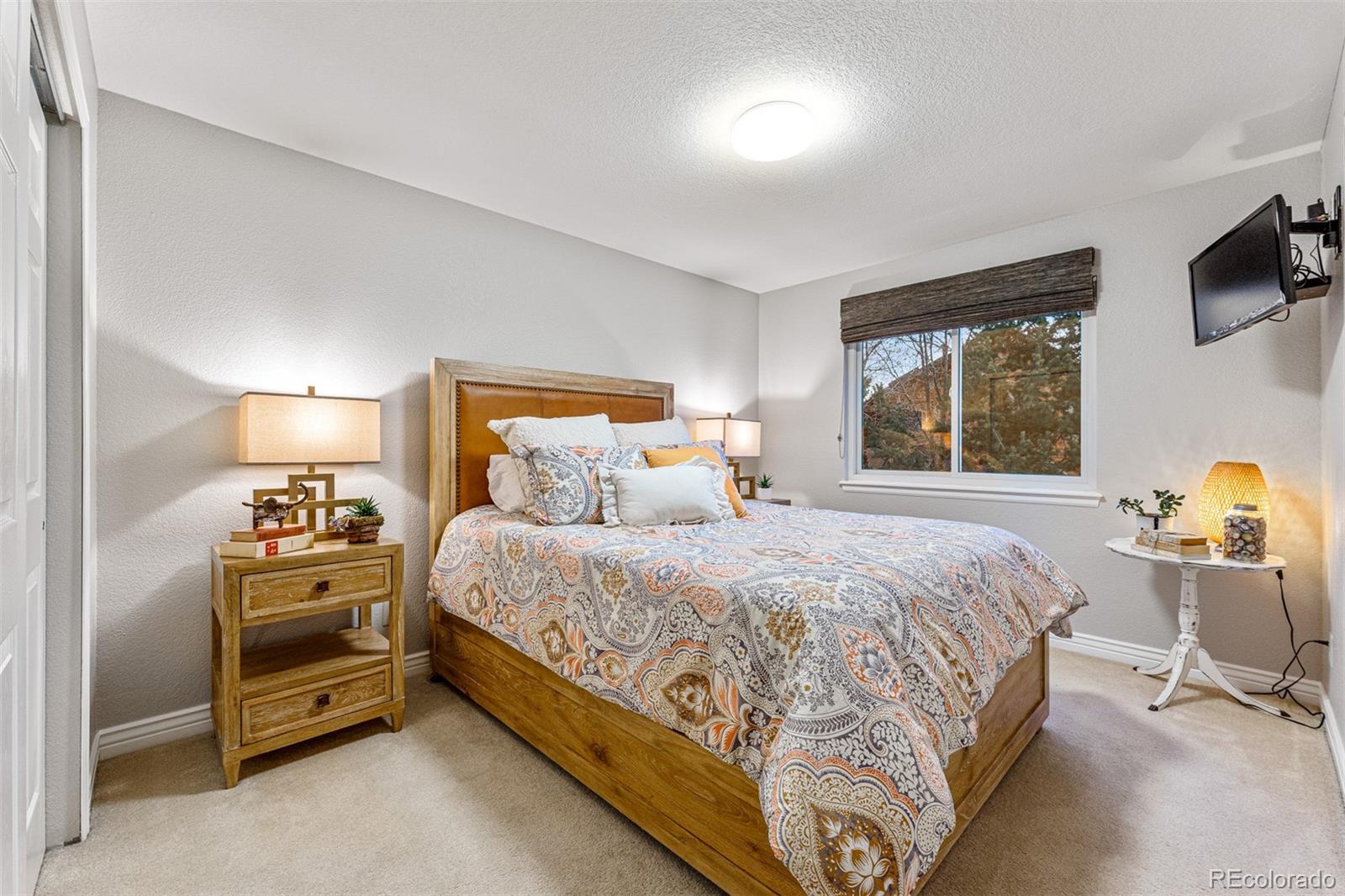 7340 Rattlesnake Drive Lone Tree, CO 80124 - Photo 24 of 33 a bedroom with a bed and a tv on the dresser