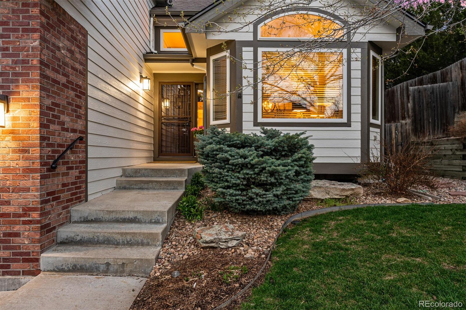 7340 Rattlesnake Drive Lone Tree, CO 80124 - Photo 3 of 33 a view of a house with brick walls and a flower garden