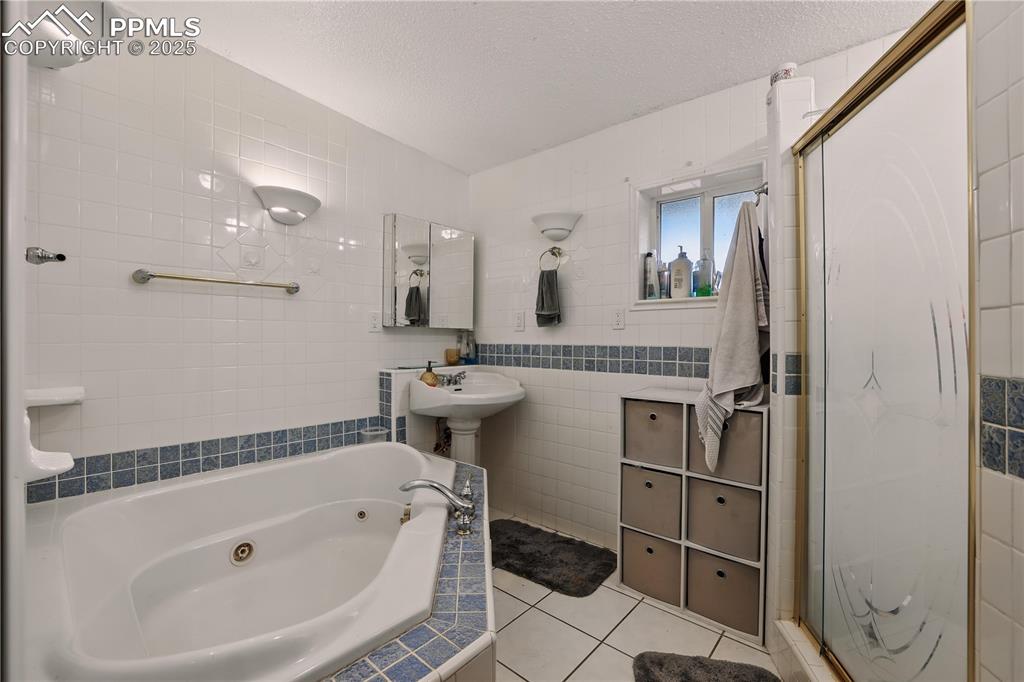 6615 Mulberry Road Calhan, CO 80808 - Photo 26 of 50 a bathroom with a bathtub a mirror a sink and toilet