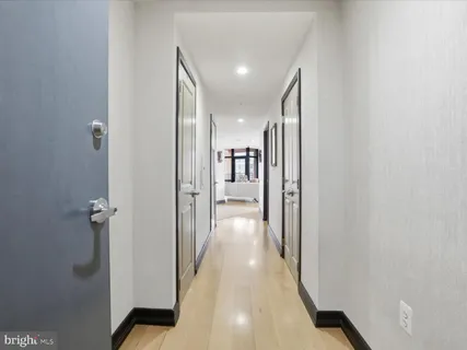 a view of a hallway with a room and wooden floor