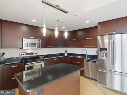 a kitchen with stainless steel appliances granite countertop a sink a stove and a refrigerator