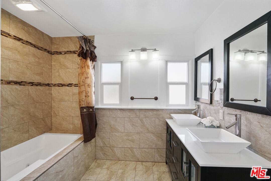 5133 Brynhurst Avenue View Park, CA 90043 - Photo 11 of 29 a bathroom with a tub sink and mirror