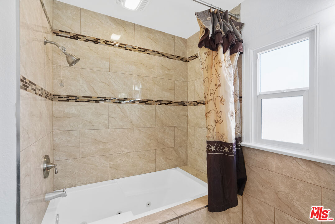 5133 Brynhurst Avenue View Park, CA 90043 - Photo 13 of 29 a bathroom with a shower and a tub