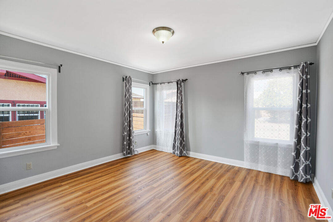 5133 Brynhurst Avenue View Park, CA 90043 - Photo 15 of 29 a view of empty room with wooden floor and fan