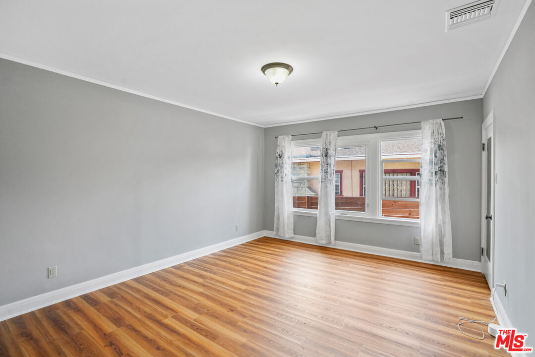 5133 Brynhurst Avenue View Park, CA 90043 - Photo 17 of 29 a view of empty room with wooden floor and fan