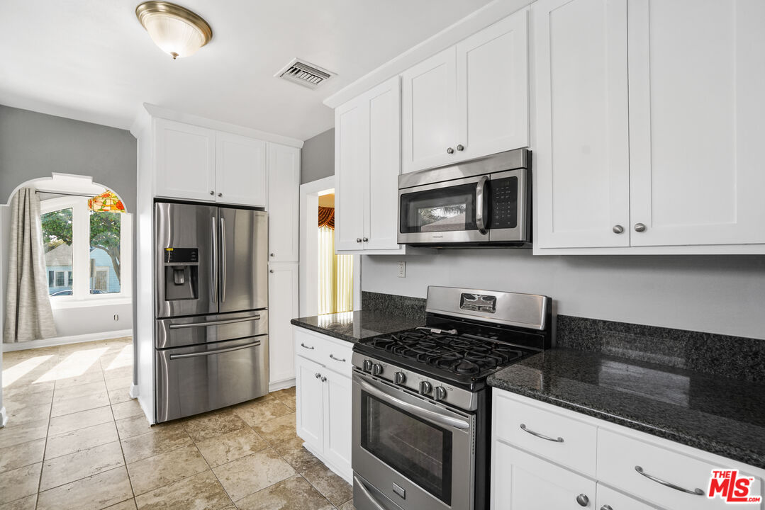5133 Brynhurst Avenue View Park, CA 90043 - Photo 5 of 29 a kitchen with stainless steel appliances granite countertop a stove a refrigerator and a microwave