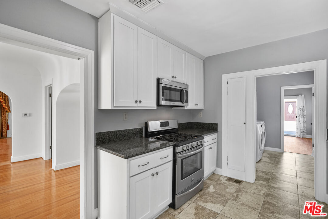 5133 Brynhurst Avenue View Park, CA 90043 - Photo 7 of 29 a kitchen with granite countertop a stove and a refrigerator