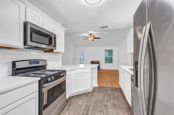 a kitchen with stainless steel appliances a stove microwave and a refrigerator