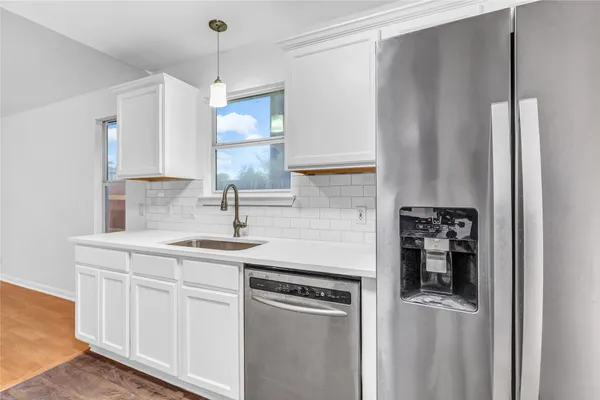 a kitchen with stainless steel appliances granite countertop a sink and refrigerator