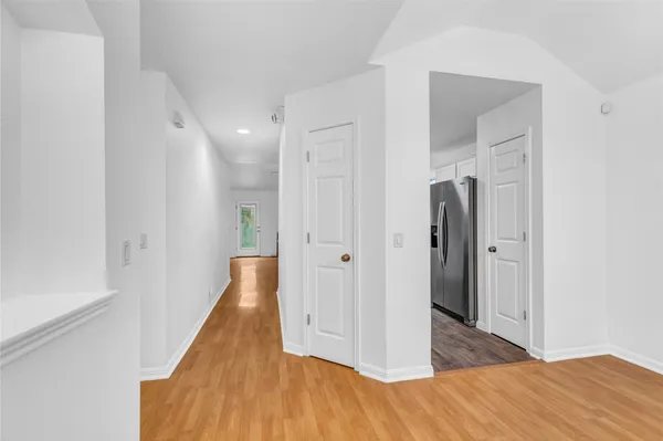 a view of a hallway with wooden floor and staircase