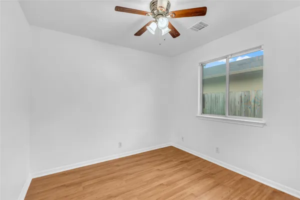 an empty room with fan and window