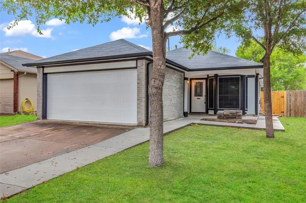 a view of a house with backyard porch and a tree
