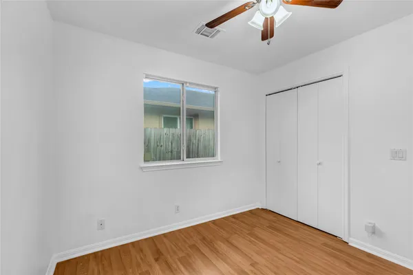 a view of empty room with window and ceiling fan