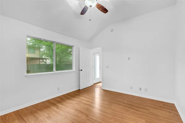 an empty room with a window and wooden floor